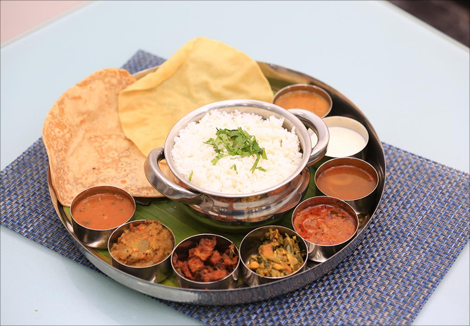Wholesome pure vegetarian thali meal with rice, curries, and breads